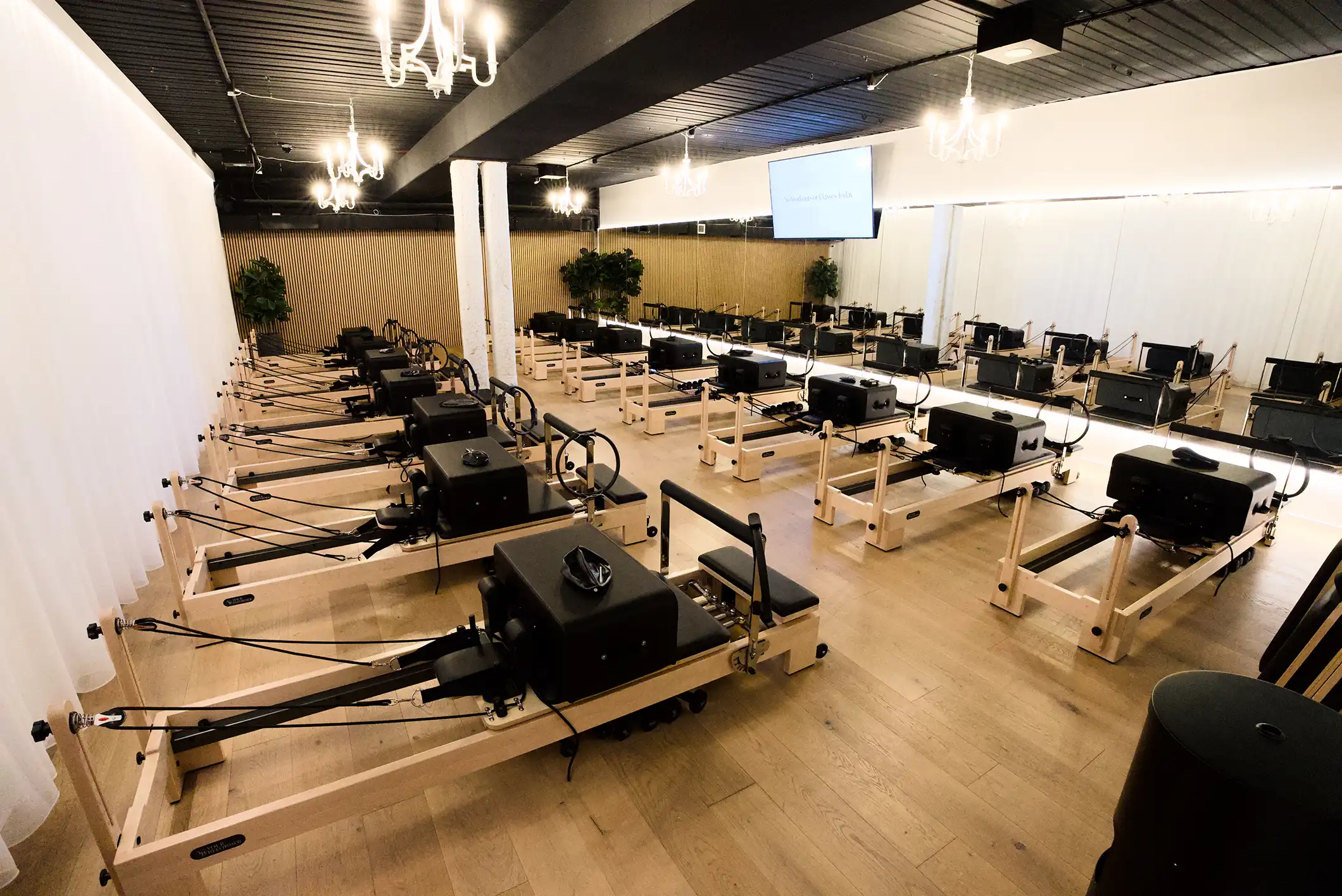 Sorrento Reformer Studio Interior - modern Pilates reformer beds with elegant chandeliers