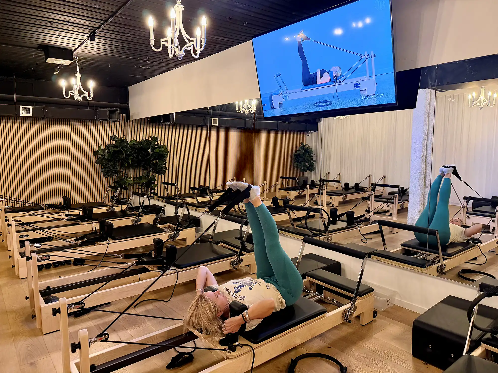 Woman performing Reformer Pilates exercises during virtual class at Sorrento Reformer