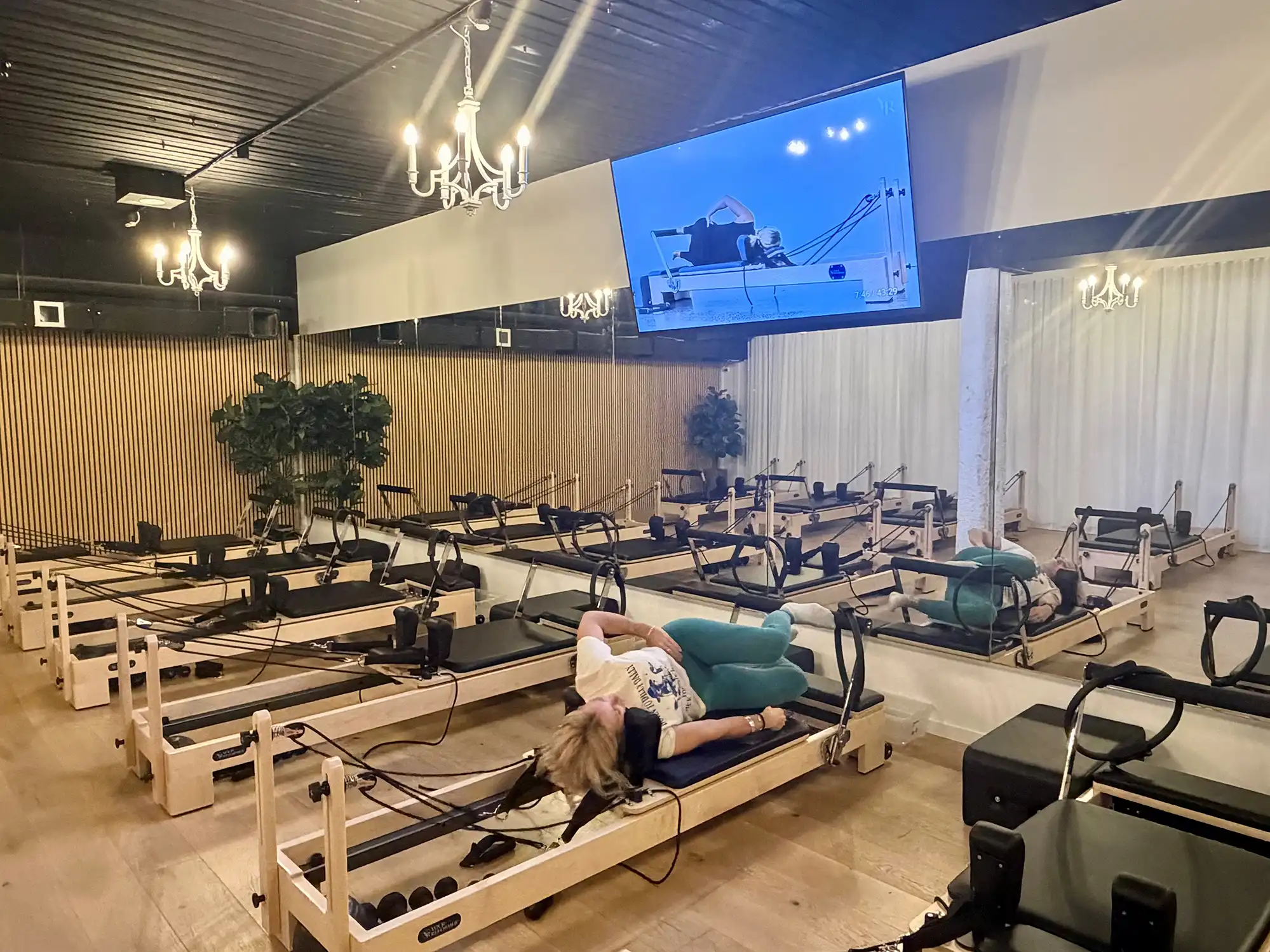 Sorrento Reformer studio setup with 85-inch screen for virtual Pilates classes